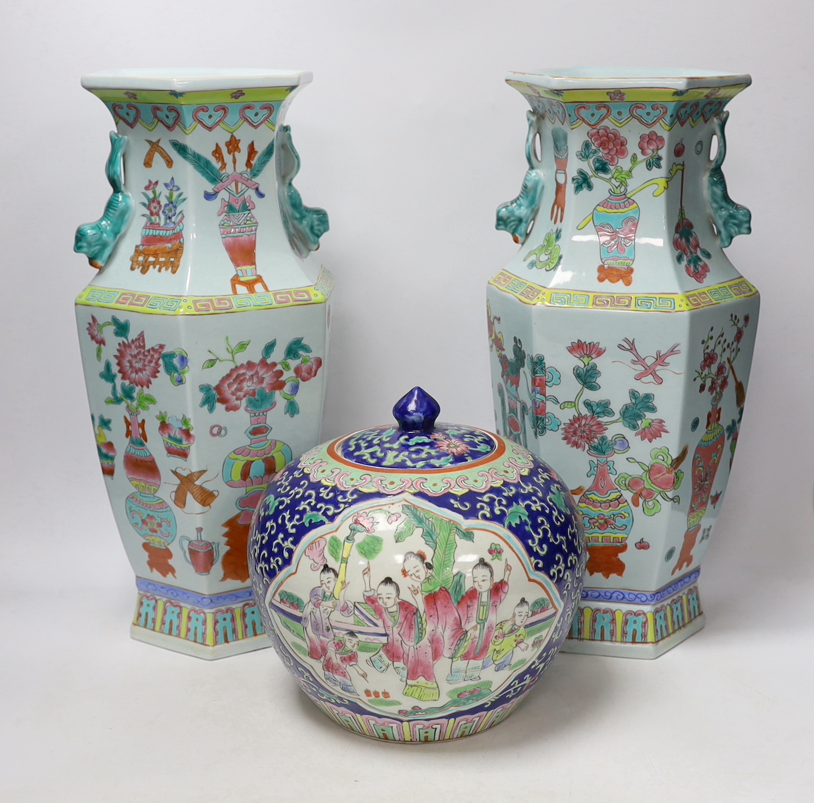 A pair of Chinese famille rose vases and a similar jar and cover, 38cm